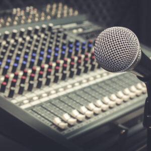 The producer music or musician equipment concept.Selective focus of single microphone with sound music mixer at the recording studio room.Vintage tone design background.